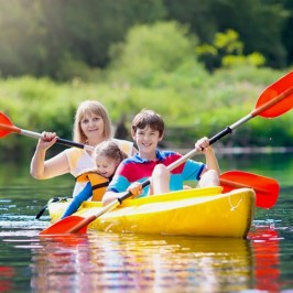 a young child riding on the back of a boat in the water