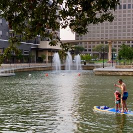 a group of people riding on the back of a boat in the water
