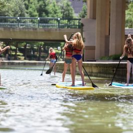 a group of people riding on the back of a boat in the water