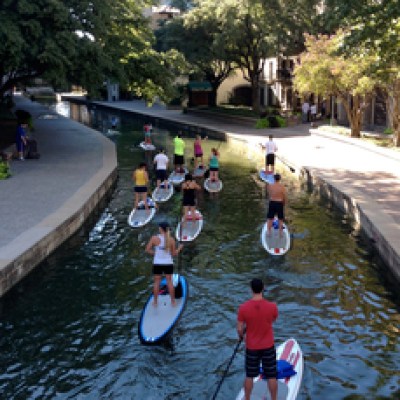 a group of people walking down a street next to a river